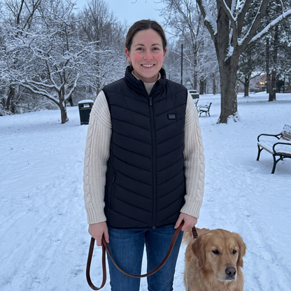 Woman wearing the Northwarm heated vest on a snowy walk with her dog